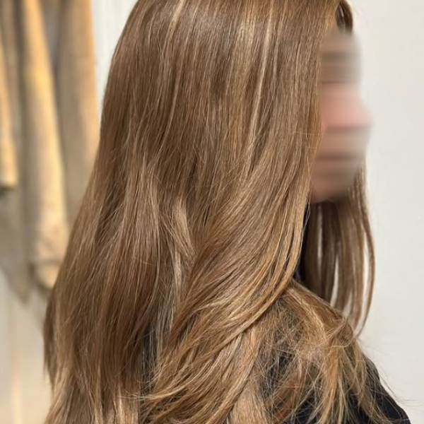Close-up of a premium human hair wig with soft layers in a golden brown shade, showcasing a natural and luxurious look.